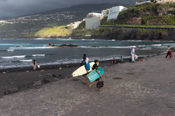 Puerto de la Cruz, Gran Canaria / Spain - April 02 2019 People on the black volcano  beach