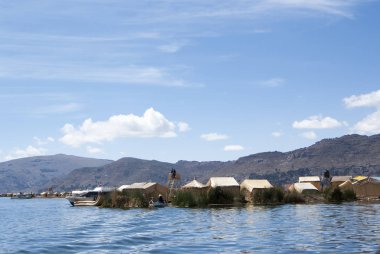 Arka planda Andes dağ sırası ile Titicaca Gölü sihirli mavi renklerde Uros yüzen adalar Manzara.