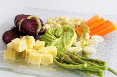 Avokado, peynir, domates, havuç, pancar ve limon ile salata bir tabak.