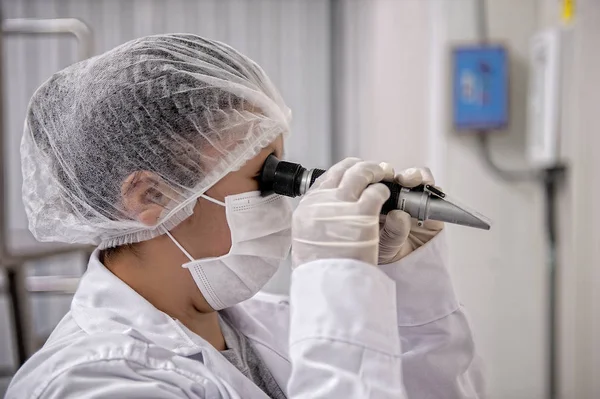 Científica mirando la muestra científica en el laboratorio — Foto de Stock