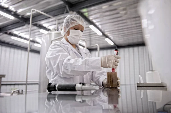 Científica protegida vertiendo líquido en un laboratorio — Foto de Stock