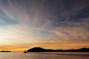 Whitsunday Adaları Sunset - su üzerinde tekneden görünümü. Renkli gökyüzündeki bulutlar