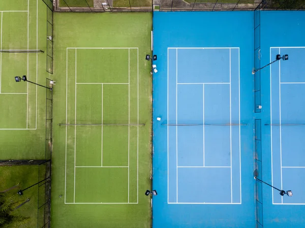 Aerial overhead shot of two tennis courts side by side, no players