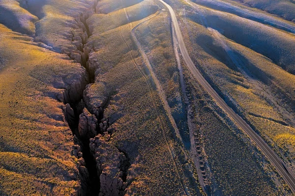 Aerial Shot Sunlit Road Sunrise Desert Side Deep Ravine Canyon — Stock Photo, Image