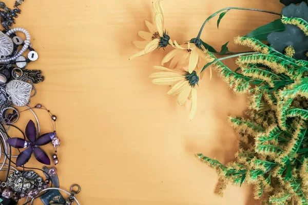 Jewels and yellow flowers on a yellow background — Stock Photo, Image