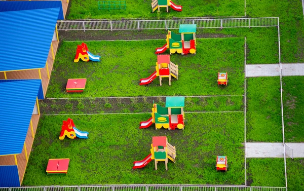 幼稚園でおもちゃのスライドや家と遊び場 — ストック写真