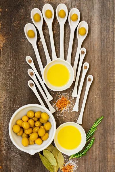 Olives, olive oil and olive wood utensils on a rustic table