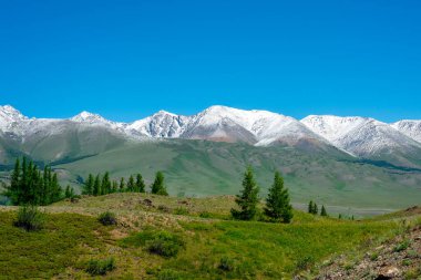 Eriyen karla kaplı bir dağ sırası. Vadiden manzara.
