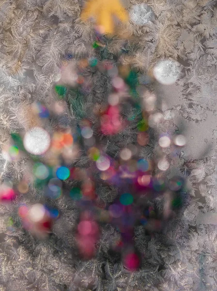 Christmas tree with blurred lights behind icy glass — Stock Photo, Image