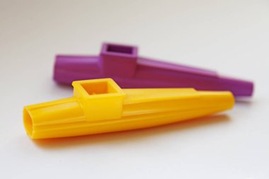beyaz arka plan üzerinde sarı ve mor kazoo