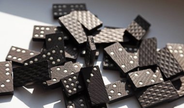 Güneş ışığı altında bir sürü domino taşı kaos içinde yatıyor.