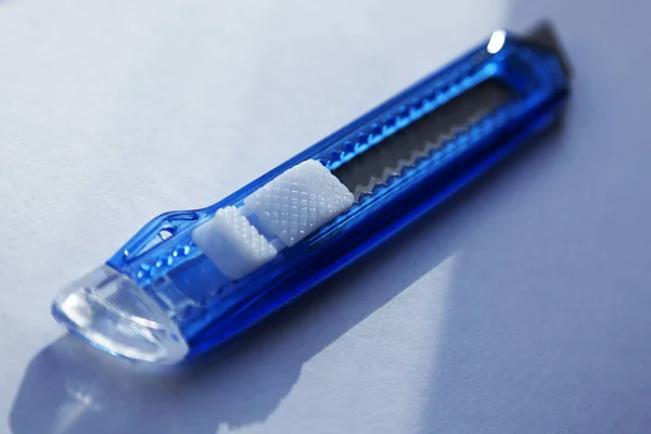 A blue carpet knife in close-up on light surface — Stock Photo, Image