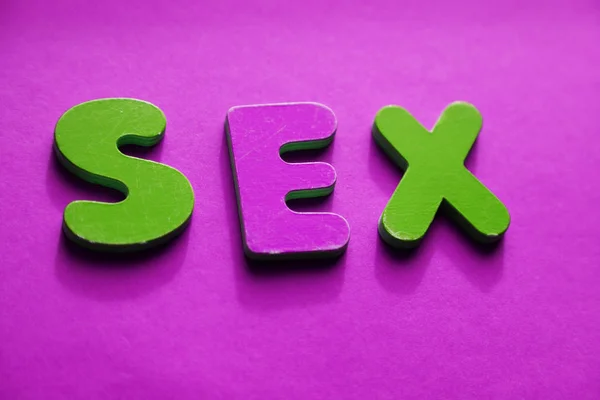 SEX words in wooden letters on pink background from above — Stock Photo, Image