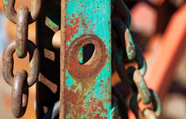 Paslı hurda ve arka planda bulanık bir zincir.