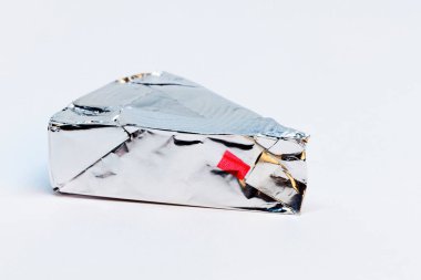 Gümüş folyoya sarılı üç köşeli peynir.