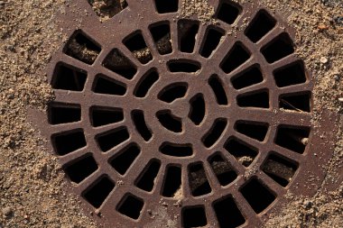 Oyun parkında demir kapaklı bir lağım.