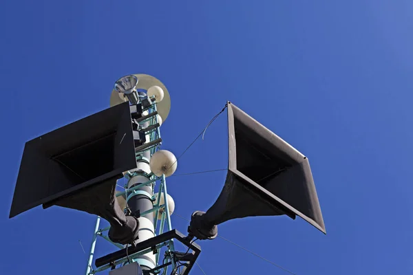 tower with two speakers in the center of the city