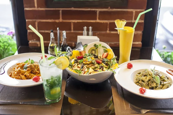 Salata ve taze içeceklerle servis edilen İtalyan makarnası