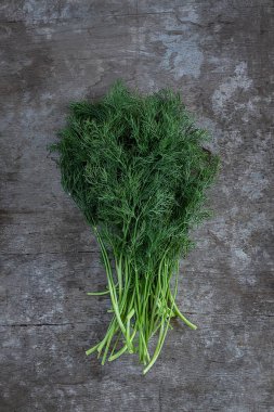 rustik ahşap arka plan üzerinde taze yeşil dereotu demet, başlık için boş alan ile dikey görüntü