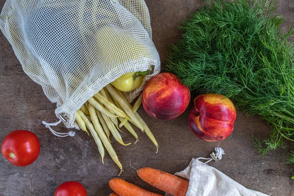 Legumes em uma mesa de madeira rústica com um saco de algodão, um desperdício zero, compras de alimentos, pimenta, pêssego, feijão amarelo, endro, cenoura, tomate Fotos De Bancos De Imagens Sem Royalties