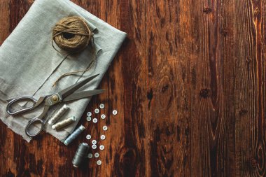 Dikiş konsepti. Makas, iplik makaraları, düğmeler ve dikiş iğneleri.