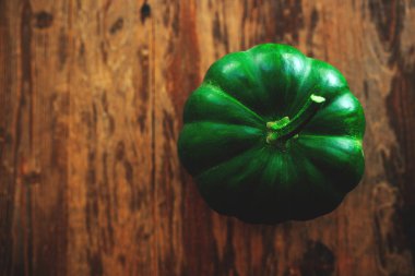 Koyu ahşap arka plan üzerinde kök ile yeşil kabak.