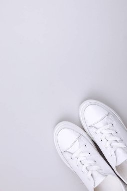 Gri arka planda beyaz spor ayakkabılar.