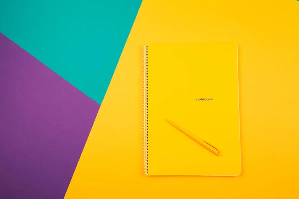 Notebook on a fashionable bright background, purple, turquoise, yellow, pen. top view, plans for 2020 — Stock Photo, Image