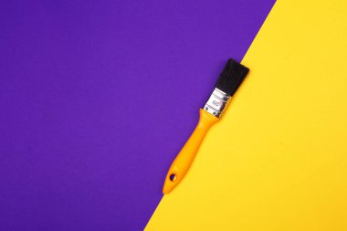 Mavi sarı mor arka plan üzerinde sarı saplı fırça. Ana trend kavramı. Trend renkler. Yukarıdan görüntüle.