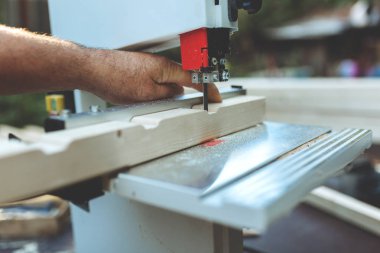 Marangoz inşaat için açık havada ahşap kirişler kesmek için doğrusal bir testere kullanır.