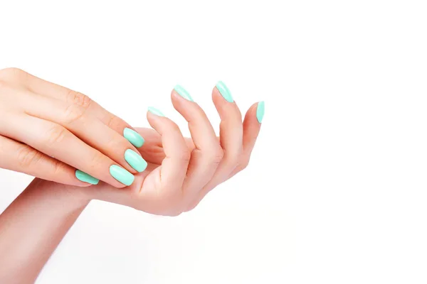 Handen van een jong meisje, manicure op een trendy achtergrond, groen Pools — Stockfoto