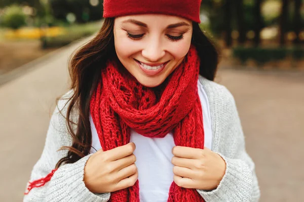 빨간 모자와 스카프 회색 가디건 일몰 태양에 야외 에서 웃고 젊은 아름다운 소녀 미소 — 스톡 사진