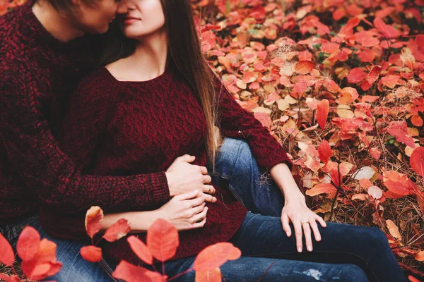 Couple vêtus de vêtements de style automne chandails famille regarder assis à travers le paysage d'automne. Forêt couverte de feuillage jaune. Promenade d'automne à l'extérieur . — Photo
