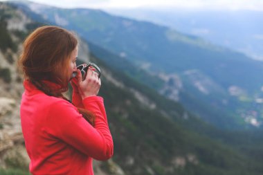 Gezginlerin çay içerken çekilmiş yakın çekim fotoğrafı. Odak dağları manzarası dışında. Genç bir turist kadın bardaktan sıcak bir içecek içiyor ve dağların manzarasının tadını çıkarıyor. Trek konsepti.