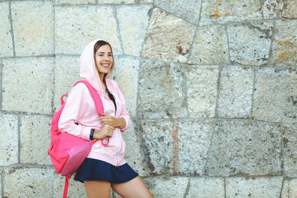 Mujer atlética joven con mochila y alfombra deportiva haciendo deporte al aire libre en traje deportivo brillante — Foto de Stock