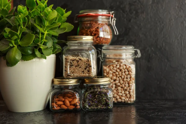 Jídlo. Surové obiloviny, těstoviny, krupice, organické luštěniny a užitečná semena ve skleněných nádobách. — Stock fotografie