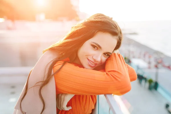 Close up shot of good looking female tourist enjoys free time outdoor near ocean or sea. — Stock Photo, Image