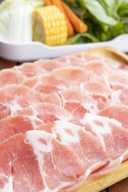 ince dilimlenmiş Çiğ domuz sebze ile ahşap plaka üzerinde 