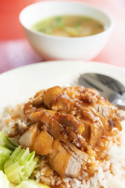 Crispy pork over rice with sweet gravy sauce and cucumber