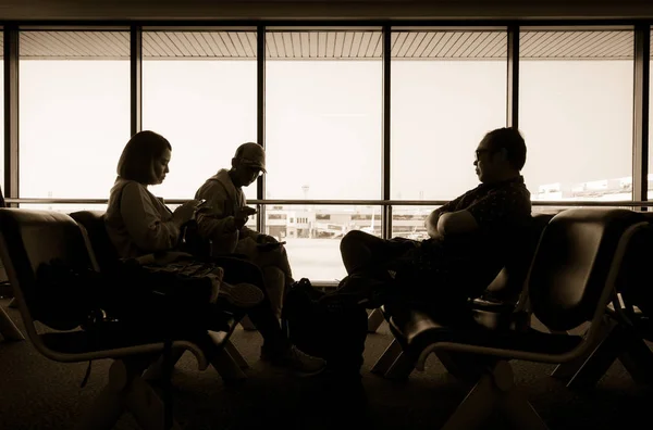 Σιλουέτα του επιβάτες κάθονται στο δωμάτιο στο τερματικό σταθμό του αεροδρομίου — Φωτογραφία Αρχείου