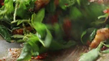 Kızarmış gevrek domuz eti ve Tayland kutsal fesleğen bir Wok yaprakları karıştırın