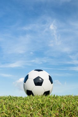 bulut ve gökyüzü arka plan ile çim üzerinde futbol 