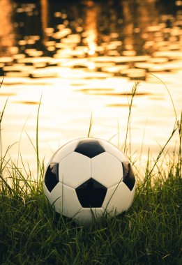 Güneş ışığı yansıması su yüzeyi ile çim üzerinde Futbol topu