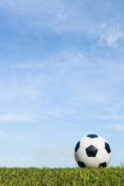 bulut ve gökyüzü arka plan ile çim üzerinde futbol 
