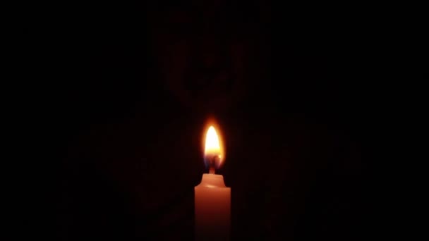 黒い背景に暗くぼやけた仏像の中で徐々に照らされたキャンドルライト — ストック動画