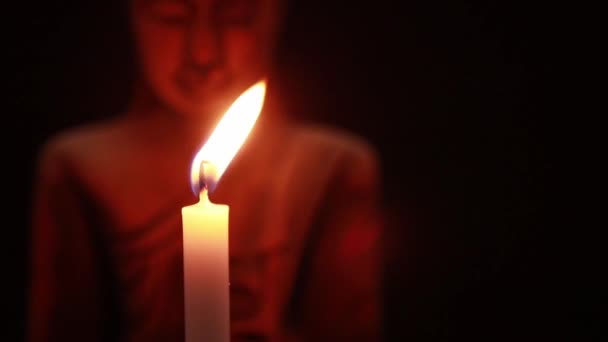 吹出白色蜡烛在黑暗和佛陀脸雕像在黑色背景 — 图库视频影像