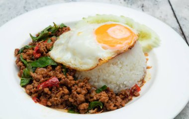 Haşlanmış pirinç, kızarmış domuz kıyması, fesleğen ve sahanda yumurta.