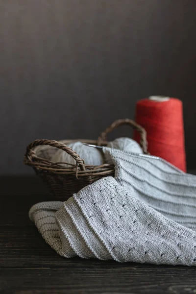 Tricô cinza com fio vermelho em uma cesta . — Fotografia de Stock