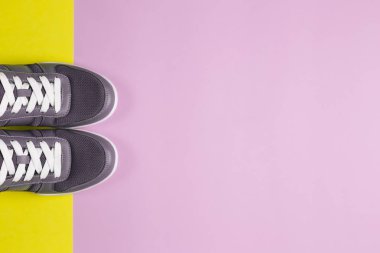 Mor ve sarı arka planda gri spor ayakkabılar. Sağlıklı yaşam tarzı ve günlük eğitim kavramı.