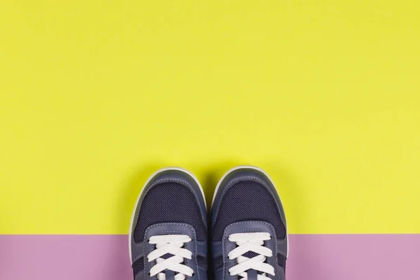 Zapatillas grises sobre fondo violeta y amarillo. Concepto para un estilo de vida saludable y entrenamiento diario . — Foto de Stock